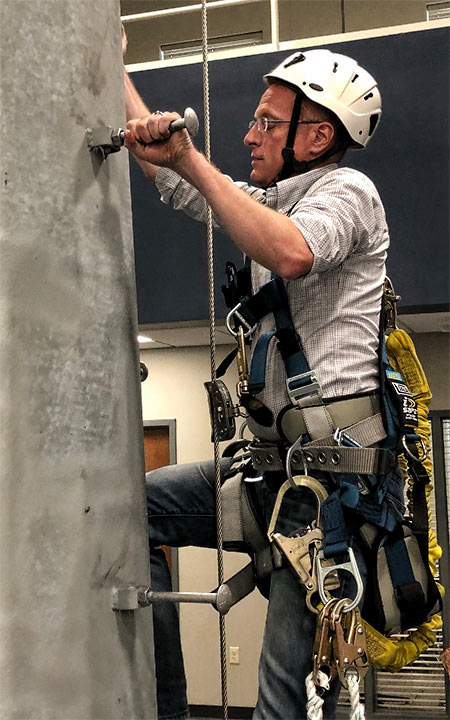 FCC Commissioner Brendan Carr practiced climbing on an indoor monopole and took those new skills out side where he climbed another structure in June.