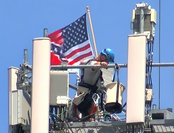 When the tower technician saw a TV reporter filming, he took down the flag. Photo: KMTV video frame capture