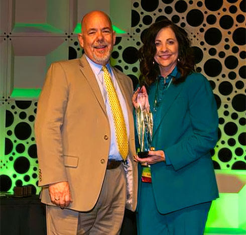 Tower Family Foundation President Jim Tracy presents Kari Carlson with the 